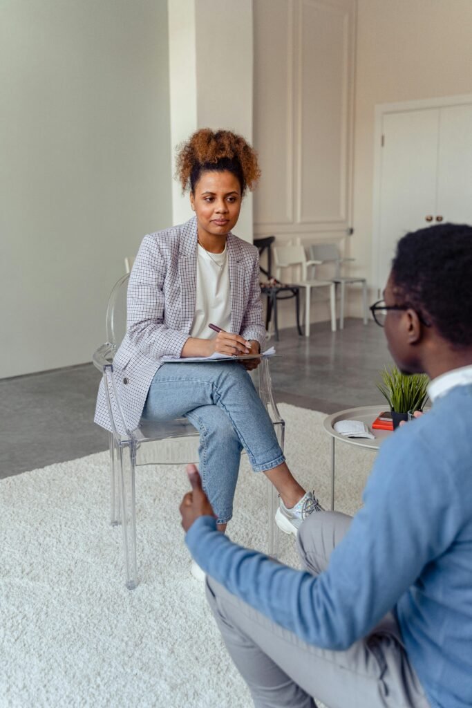 Professional therapist discussing with a client in a modern office setting.